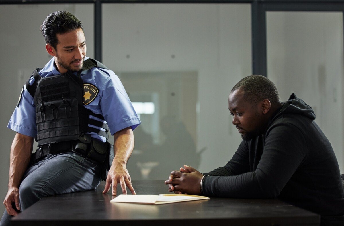 Police, interrogation and black man, suspect or criminal investigation for crime at station. Africa
