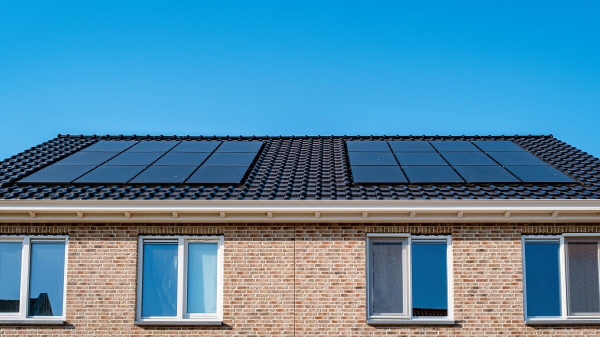 A brick building with solar panels under a blue sky