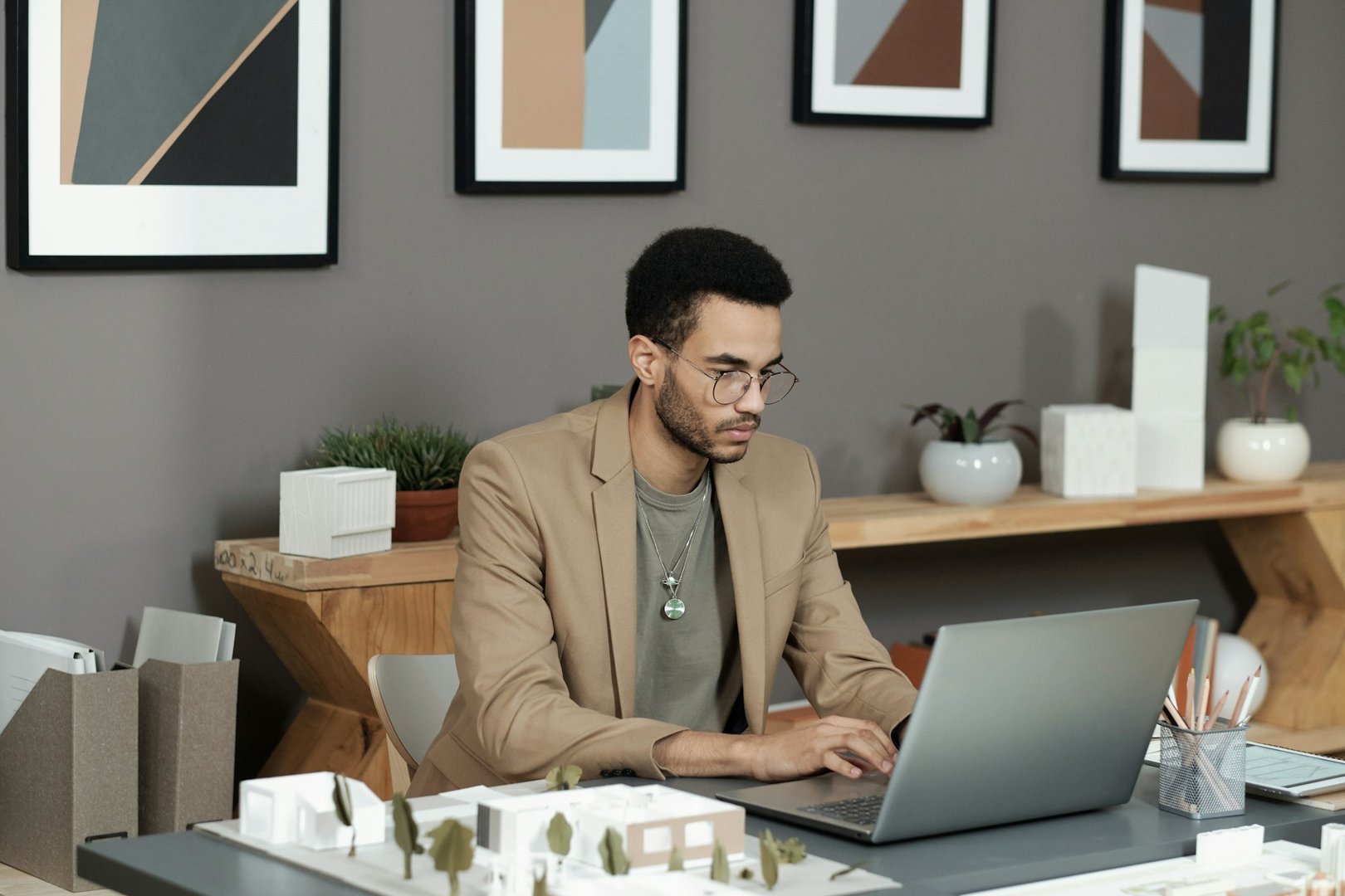 Young serious businessman in formalwear typing on laptop keypad