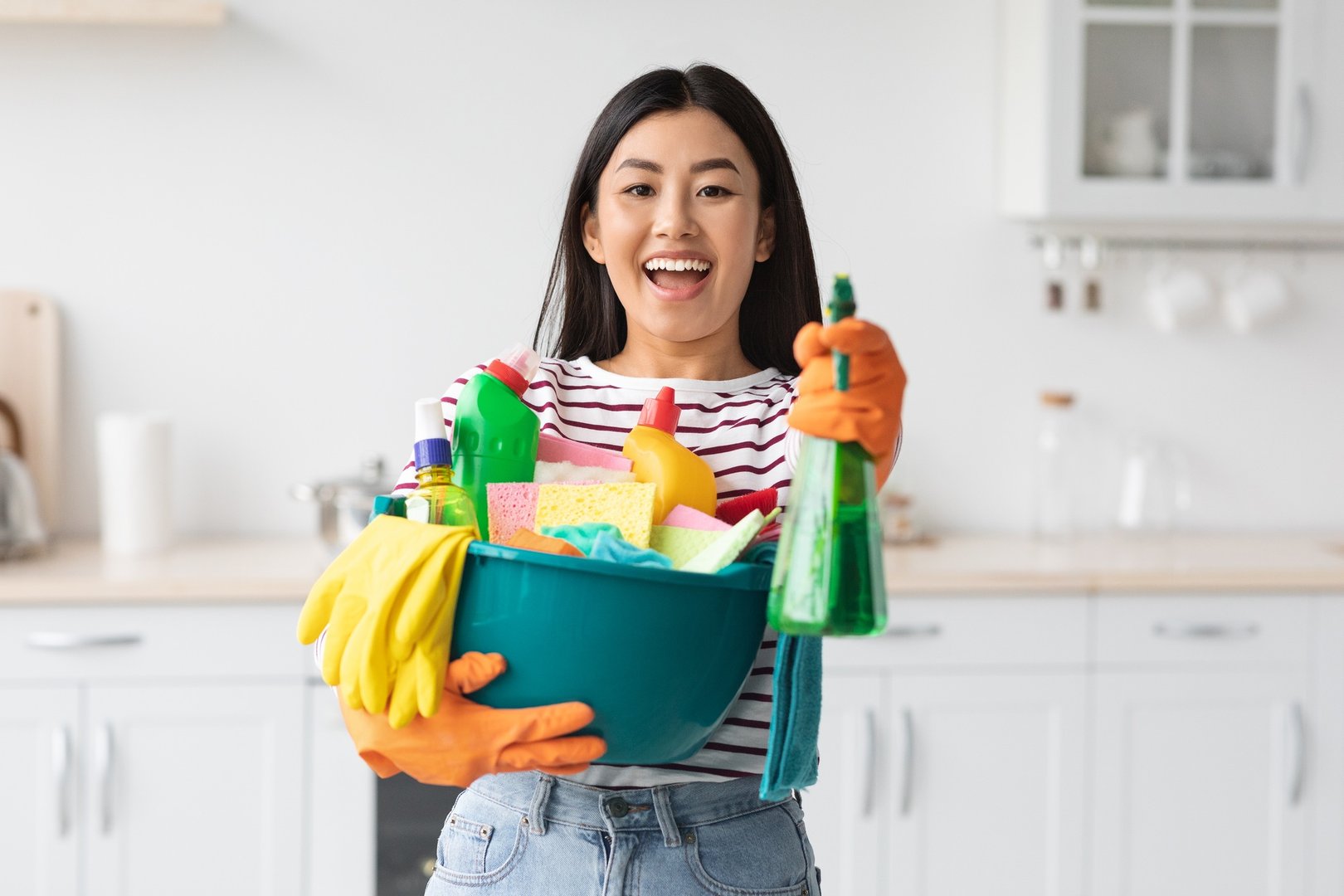 Smiling asian female house-keeper cleaning apartment, copy space