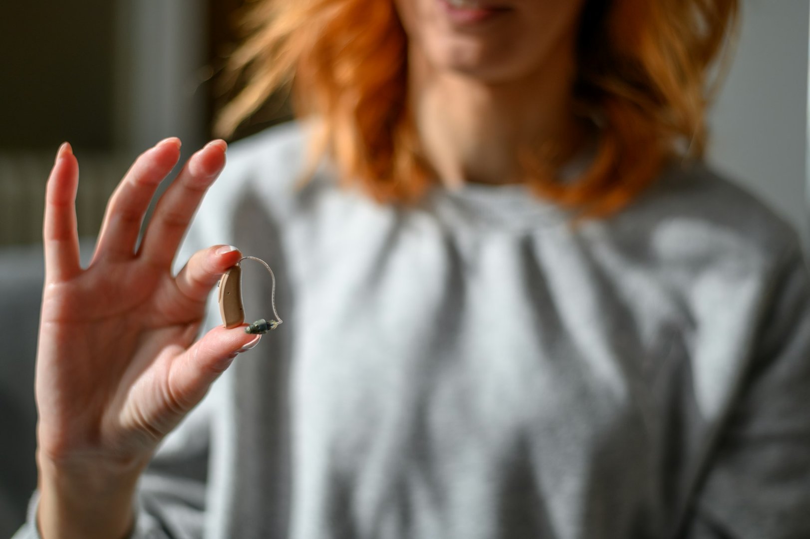 Woman hands holding a hearing aid