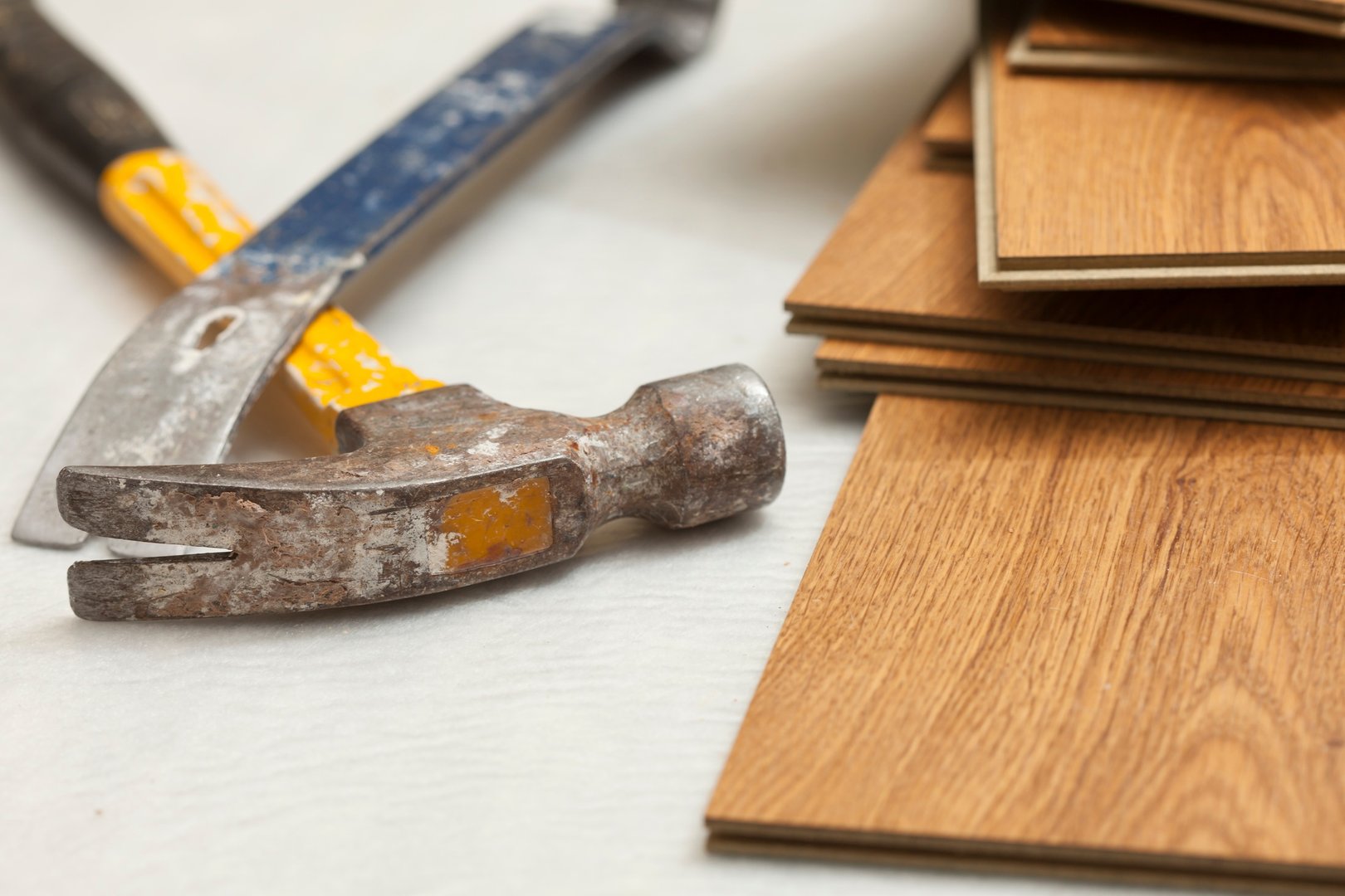Worn Hammer and Pry Bar with Laminate Flooring Abstract.