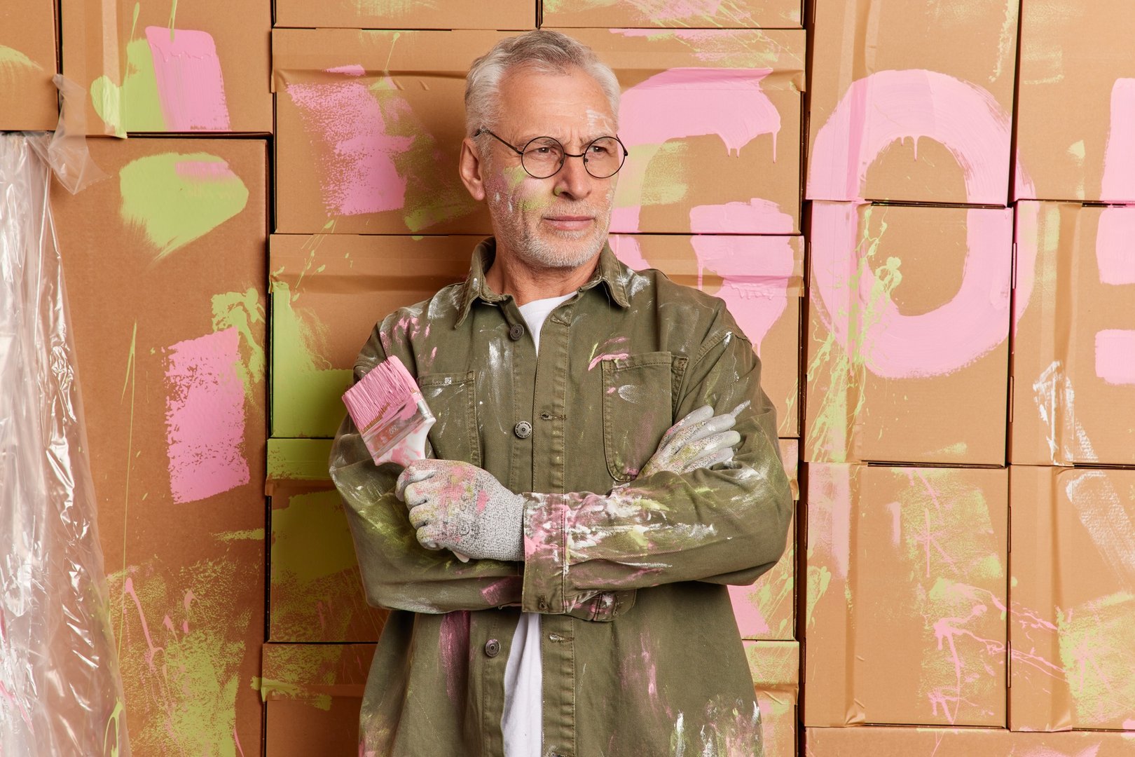 House remodel and painting service concept. Serious bearded man crosses arms and looks pensively asi
