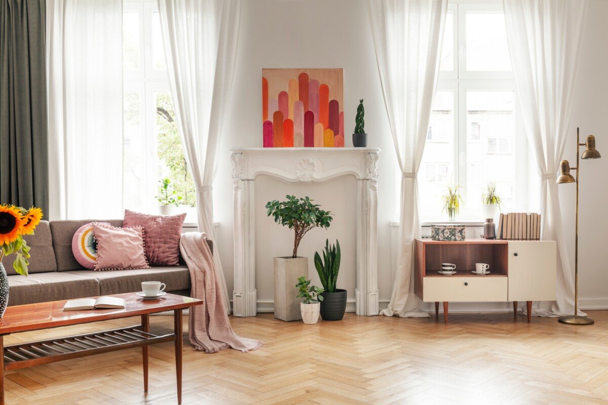 Drapes at windows and poster in white living room interior with