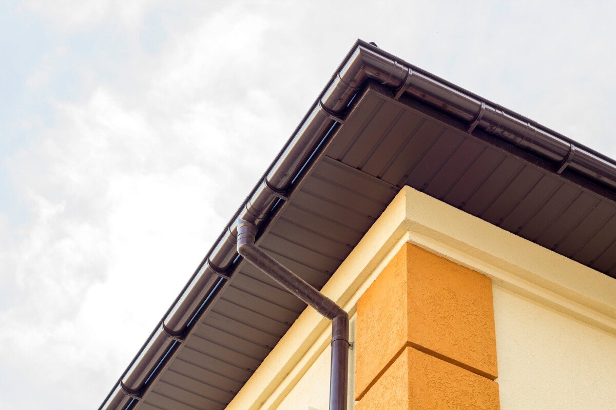 Close-up detail of cottage house corner with brown metal planks siding and roof