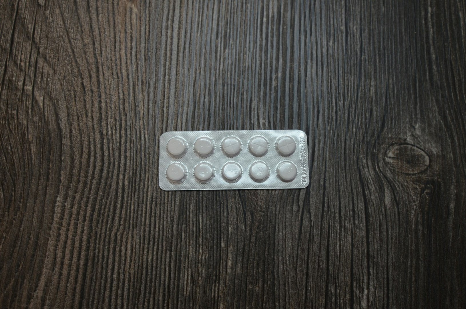 The pills lying on the wooden table. The pills close up.
