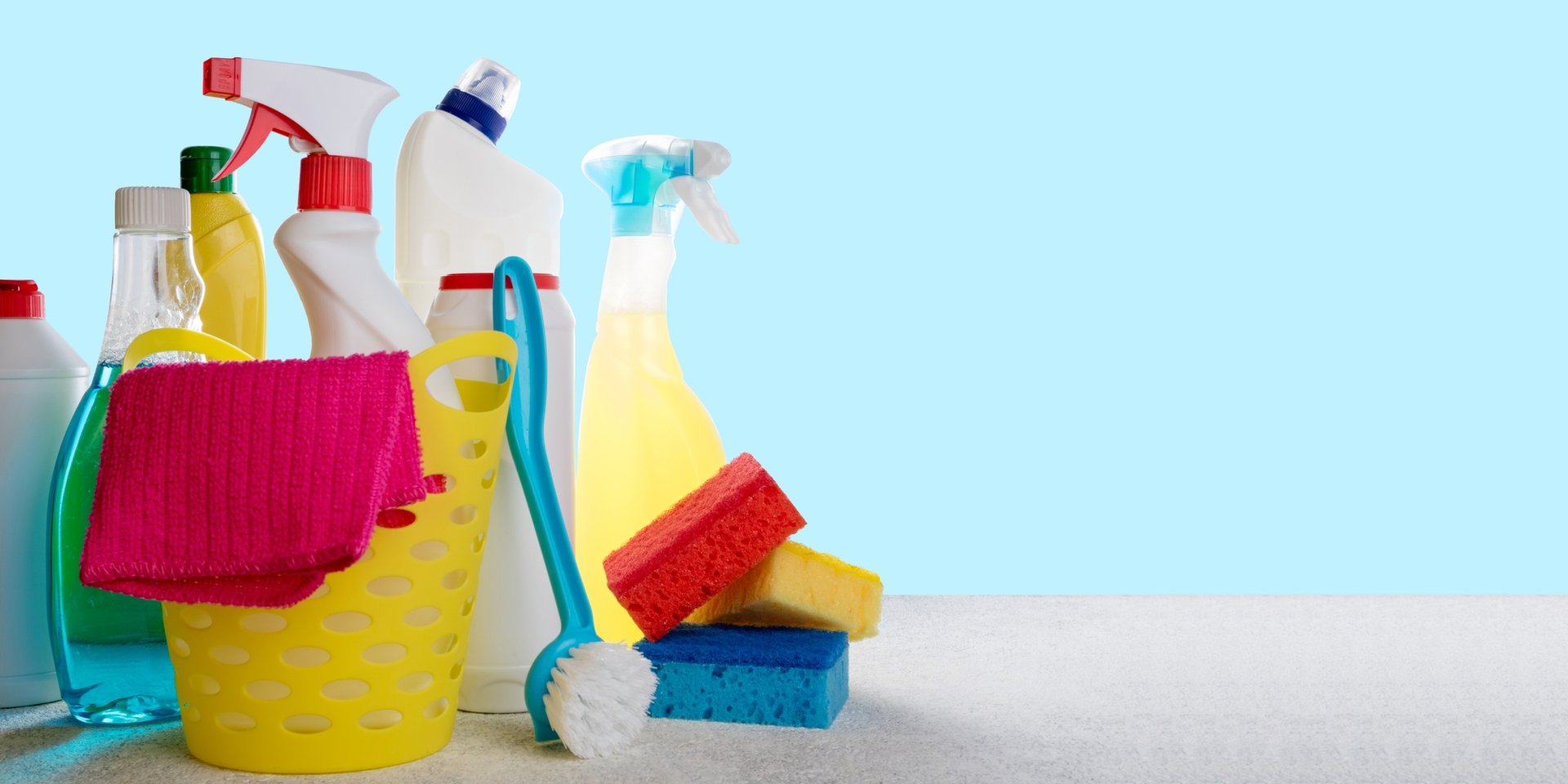 Basket with cleaning products on blue background. Cleaning with supplies, cleaning service