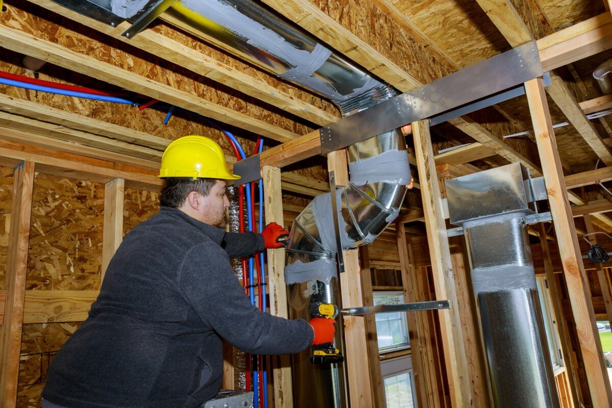 Workers making final air duct conditioning HVAC system ventilation pipes stands for heating