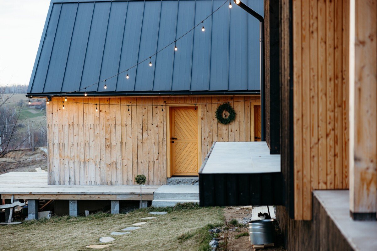 Modern wooden cabin with porch and string lights