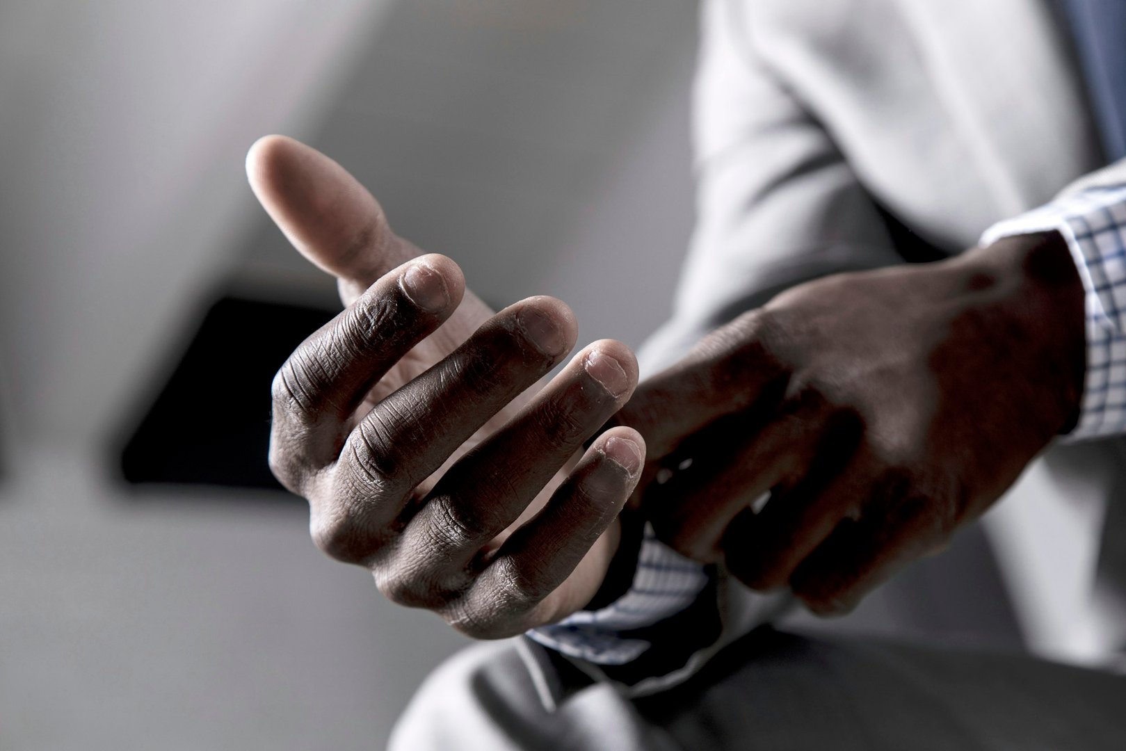 Man in suit cracking knuckles against a grey backdrop
