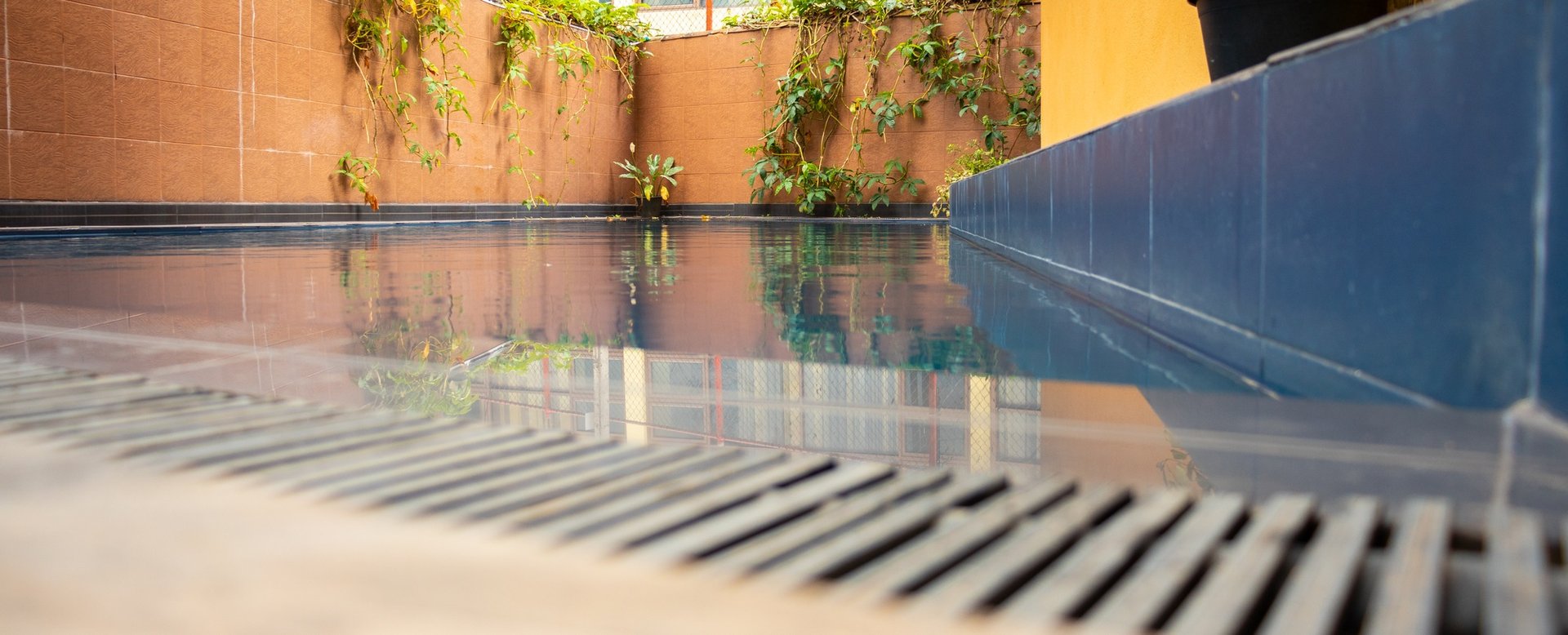 Swimming pool gutter and water surface low angle view.