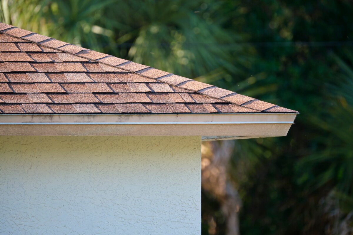Closeup of house roof top covered with asphalt or bitumen shingles. Waterproofing of new building