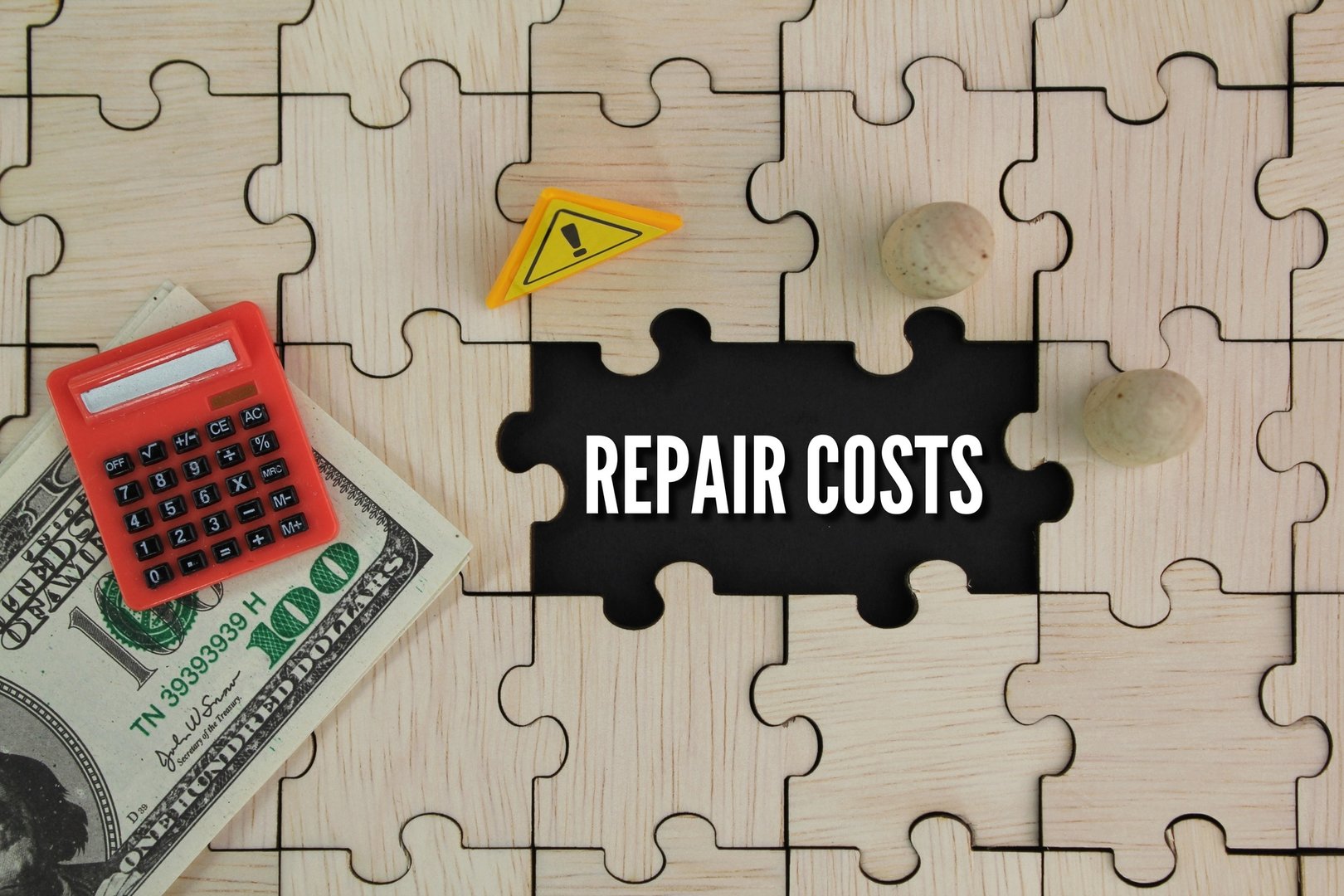 wooden puzzle, caution sign, paper money and calculator with the word repair costs