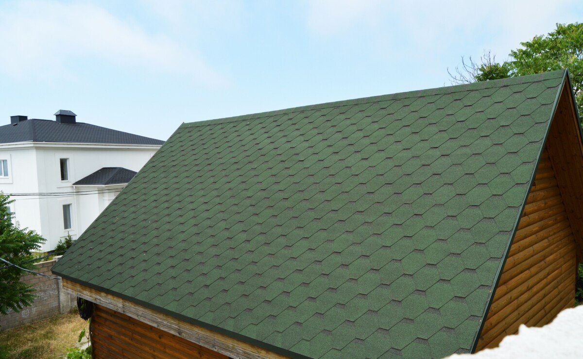 Modern house with green metal tiled roof and wooden siding walls