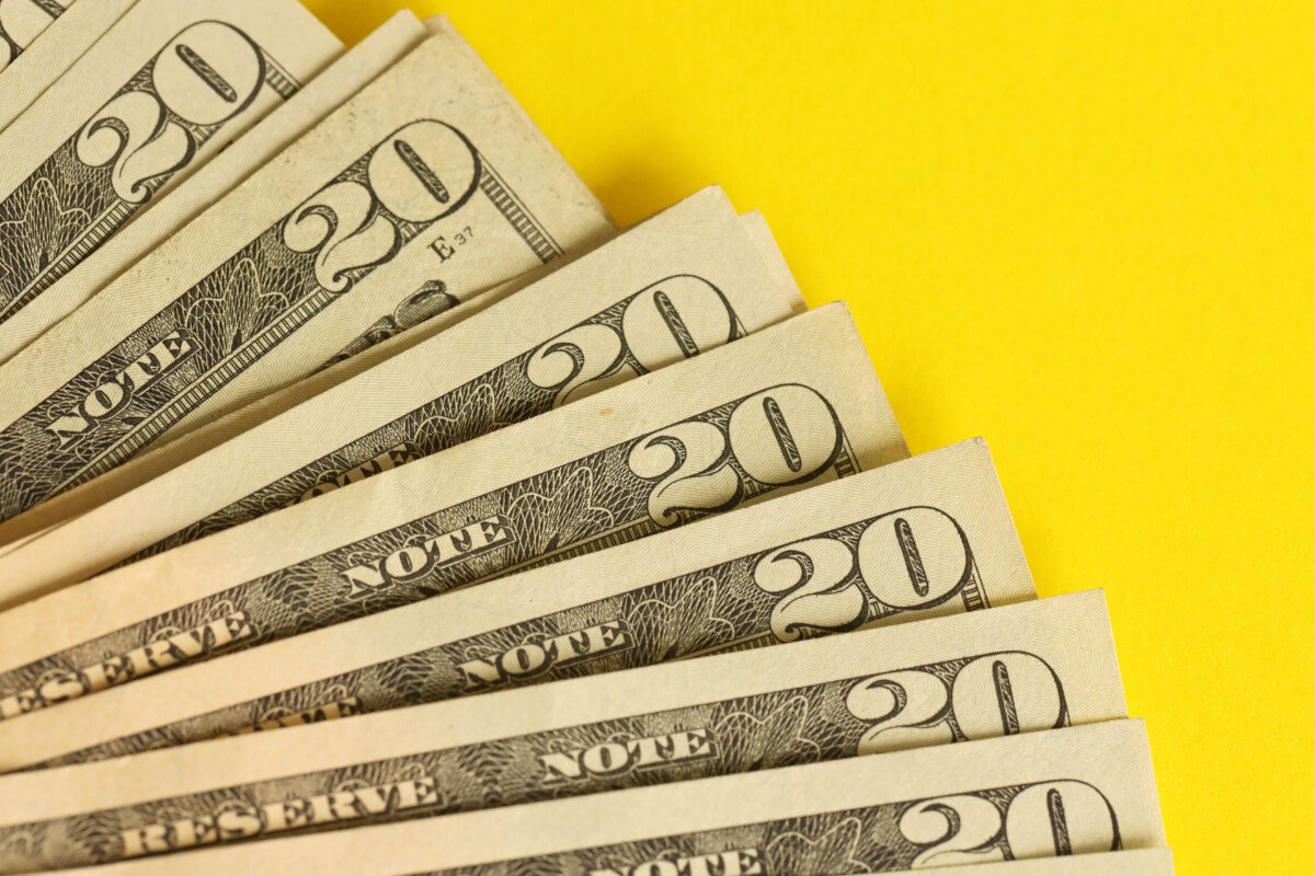 Big amount of old twenty dollar bills on golden background. Money earnings, payday or tax paying period concept