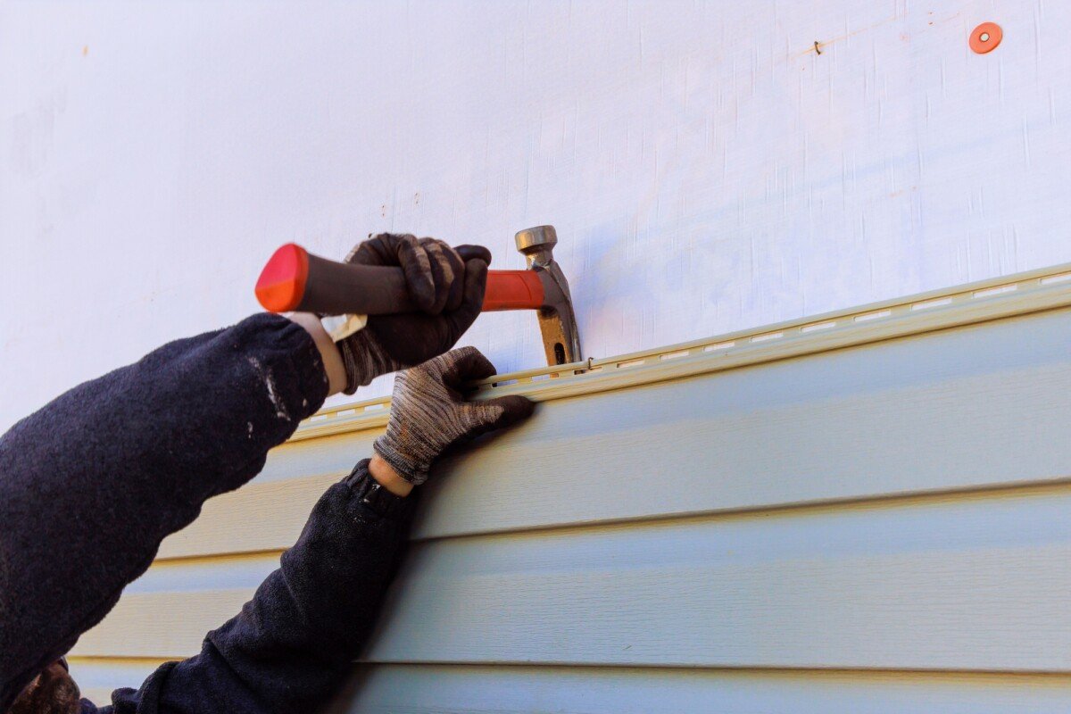 Damaged plastic siding of house is replaced during a reconstruction of its exterior