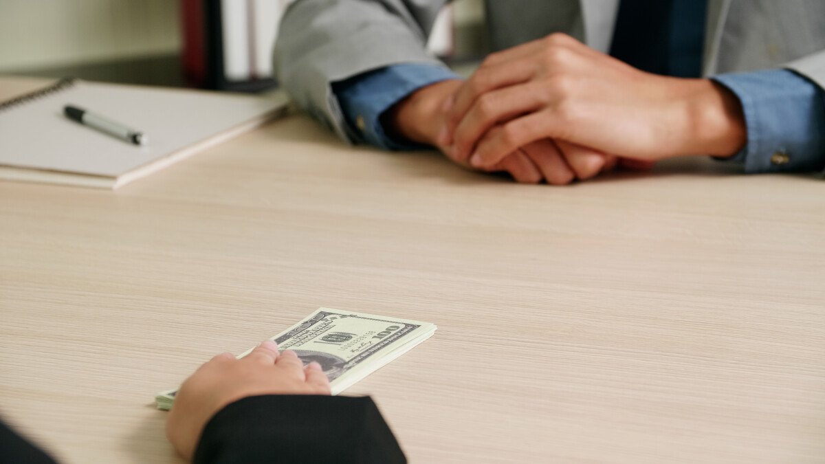Businessman take bribes from entrepreneur, they agree to do business together.