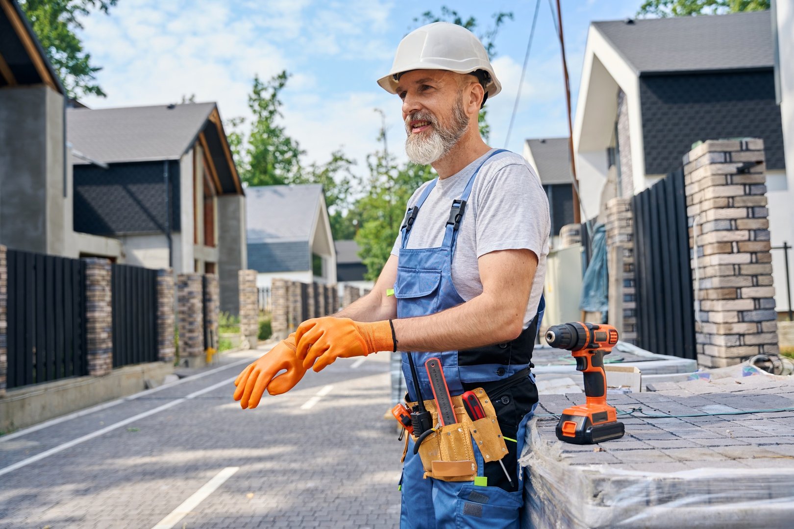 Contented bricklayer preparing for masonry work on building site