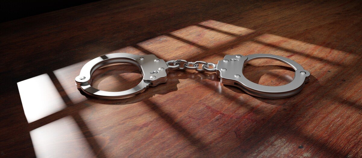 Jail bar shadow and handcuff on a wooden table. Prison, conviction and incarceration. 3d render
