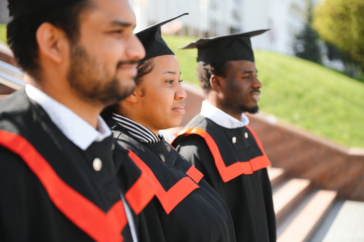 Diverse international students with diplomas at university campus.