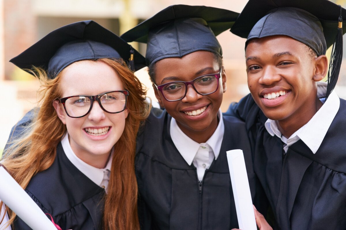 Portrait of a happy group of students standing outside on their graduation day.
