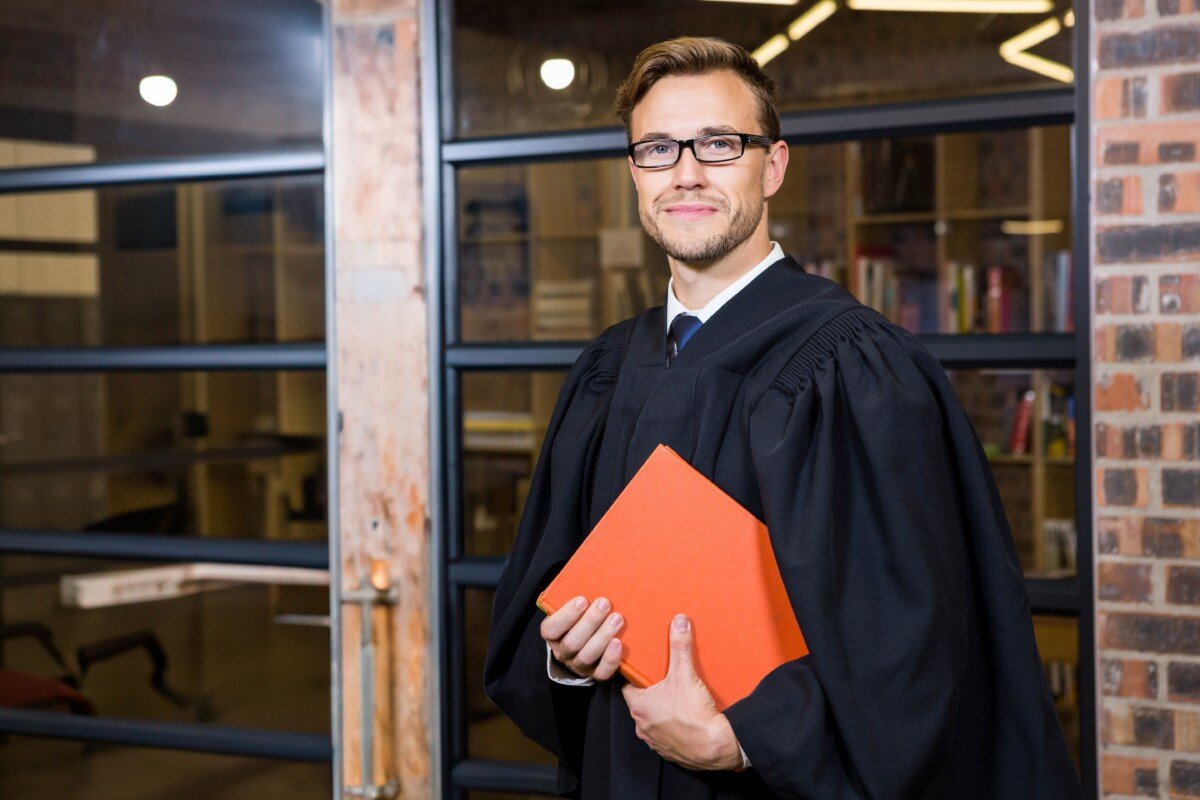Orange folder resting on glass door handle, with brick wall and bookshelves behind. Professional, legal, library, formal,…