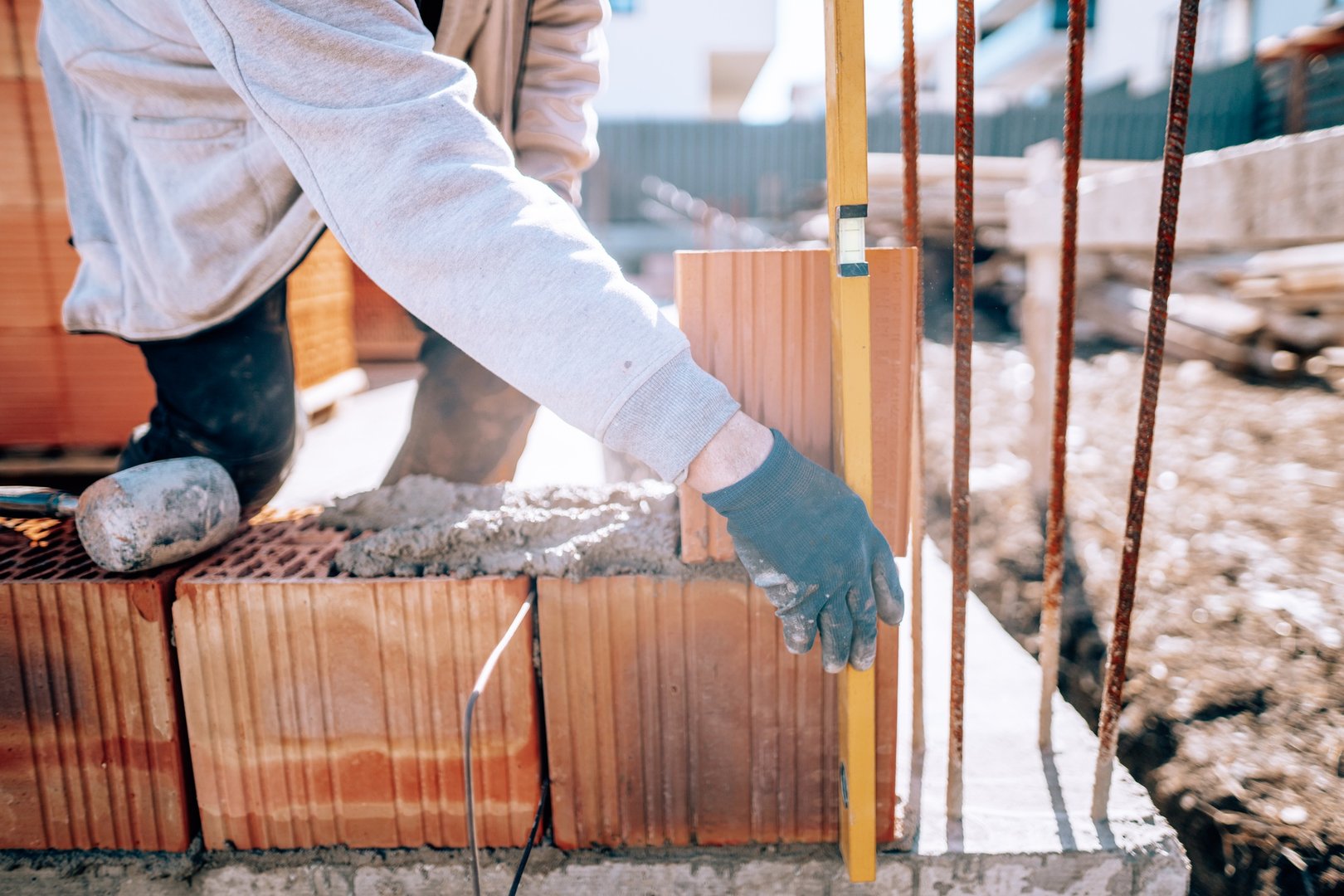 Bricklayer industrial worker installing brick masonry