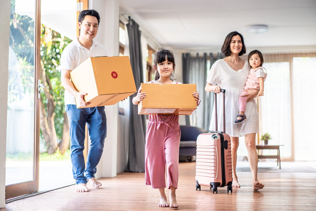 Asian big family moving packing boxes and cloth baggage to new house. Mother holding little cute baby girl with suitcase…