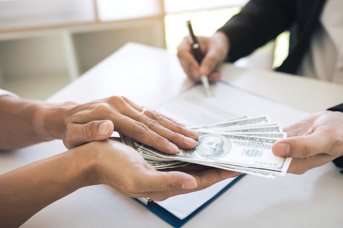 Money in the hands of businessmen who are submitting to entrepreneurs to force the signing of contract documents about…