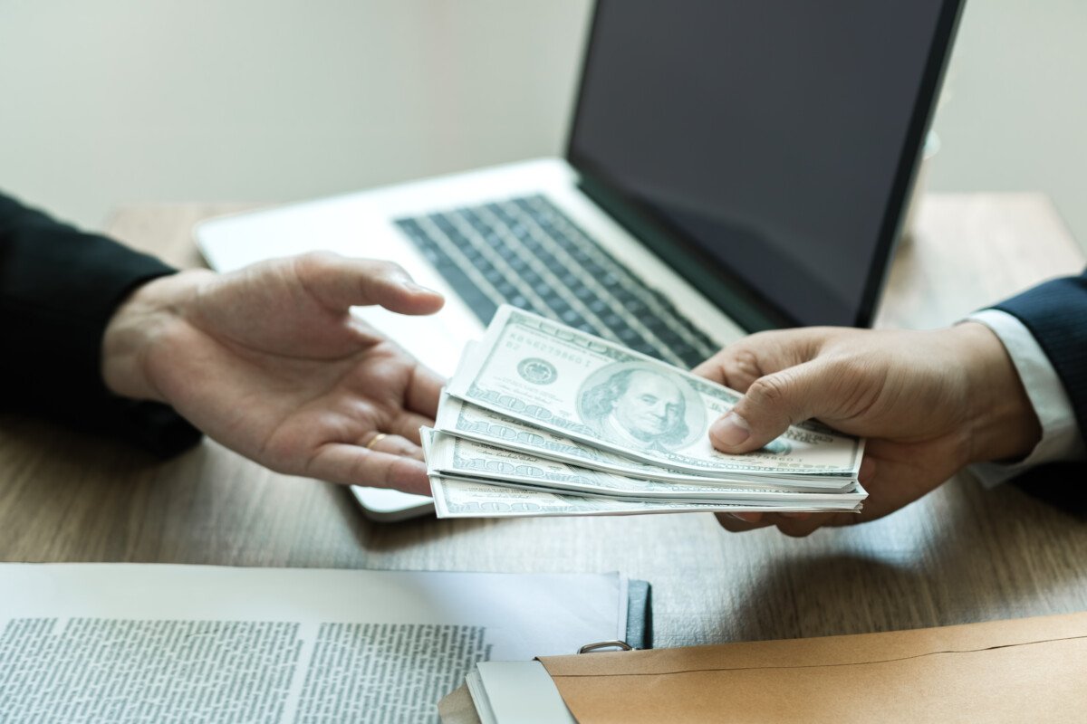 Entrepreneurs are receiving money that is a bribe of their partners with both of whom are corrupt in the company room.
