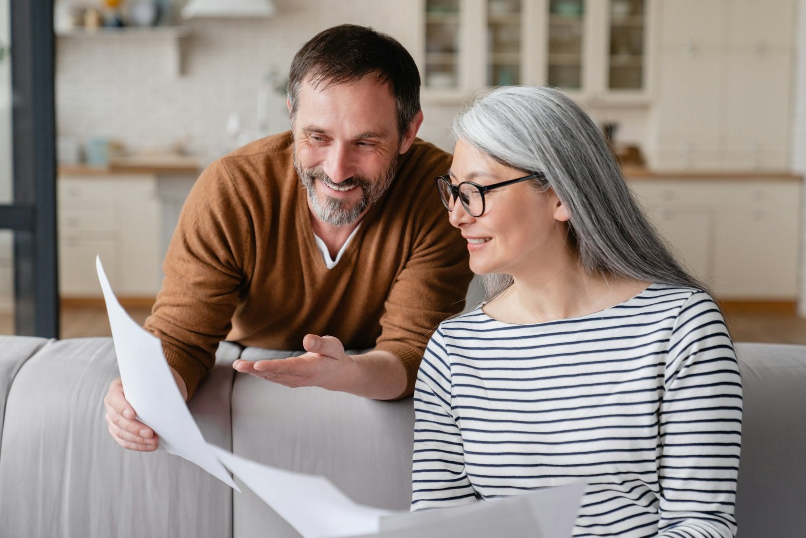 Happy mature couple checking documents, middle-aged family celebrating success,paying