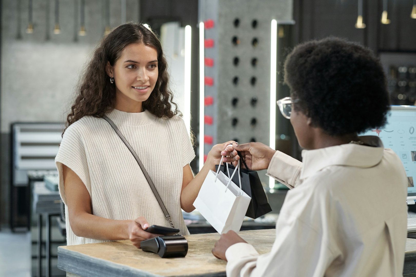 Happy young brunette female paying for purchase
