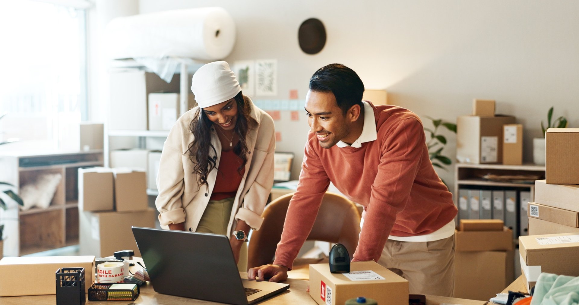 Business partners, moving boxes and laptop for online meeting, startup and funding for costs, couri