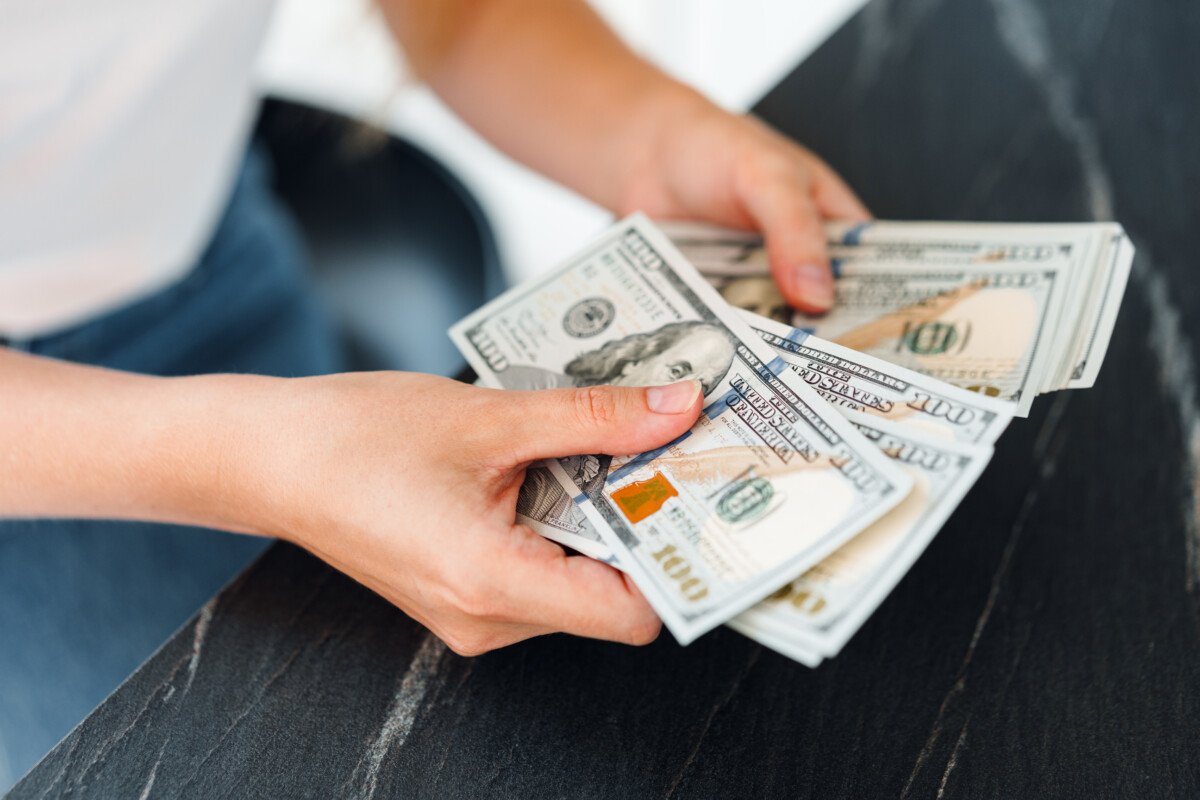 Close up photo of female hands counting dollar banknotes