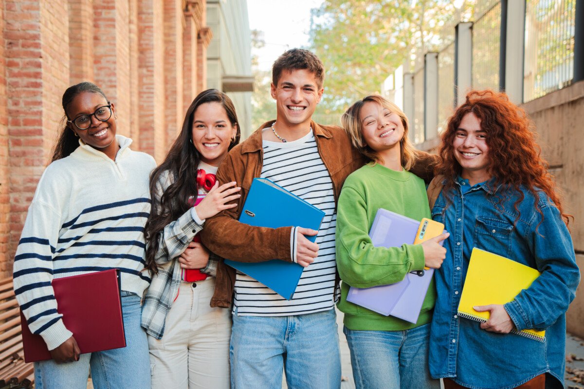 Group of real teenage students having fun jumping up at university campus. Young adult multiracial friends leaping at high…