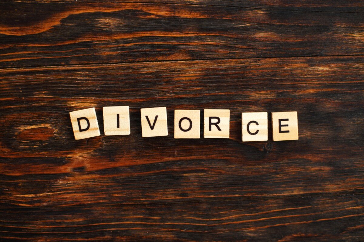 inscription divorce made by wooden blocks on wooden background. broken family concept.