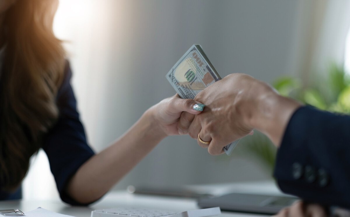 A female lawyer or business legal consultant receives a bribe or tribute from her client in the office. Corruption concept.…