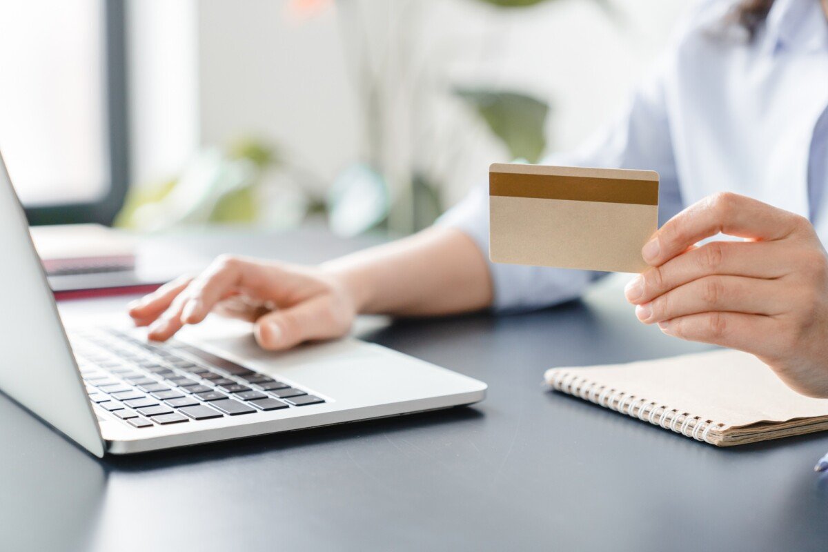 Cropped image of woman`s hands holding credit card and typing on laptop.Online shopping