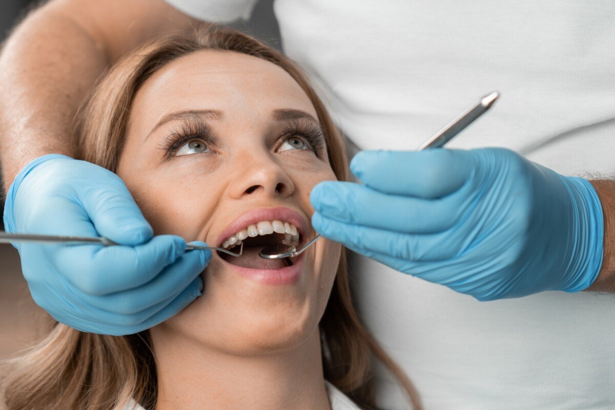 In the dental chair, a woman happily demonstrates her new smile, which she received thanks to the