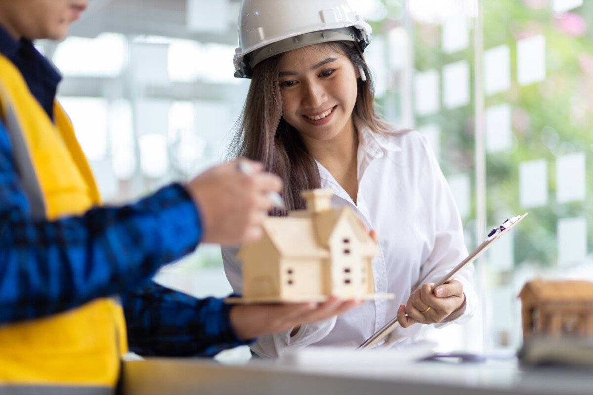 Happy female architect designer in the office works with her colleagues, engineers, contractors together to design and cost…