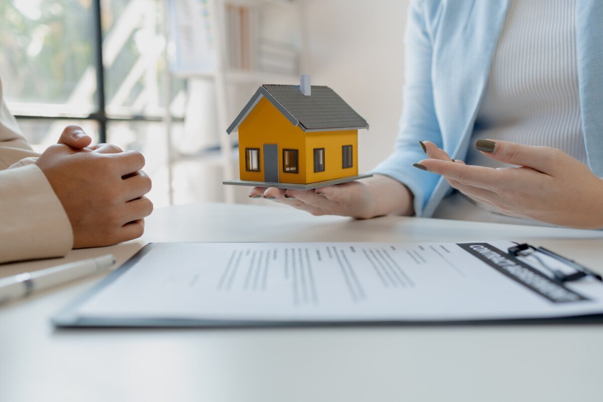 A real estate agent sits in her office, The salesperson is presenting what the home the customer is about to buy looks…