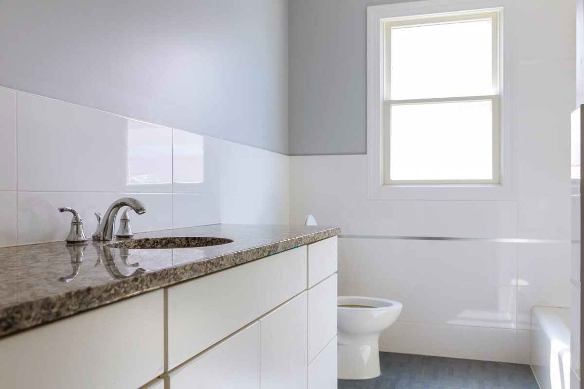 Master bath in new construction home with wood cabinetry large luxury white marble lined bathroom in an expensive home