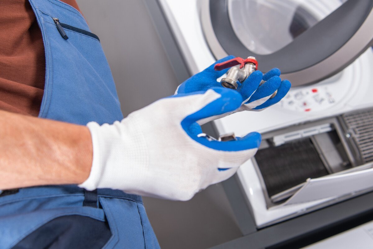 Caucasian Plumber Installing Additional Water Supply Outlet For Residential Washing Machine. Plumbing Industry Theme.