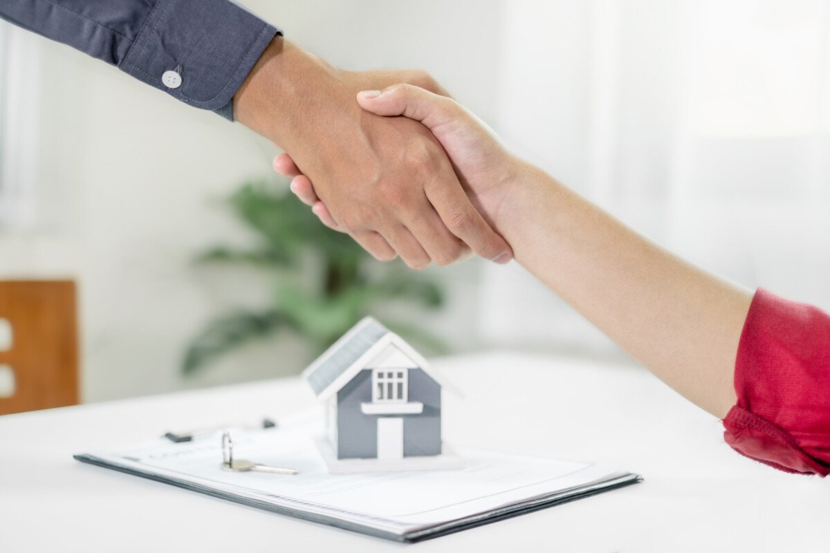 Businessmen and brokers real estate agents shake hands after completing negotiations to buy house insurance and sign…