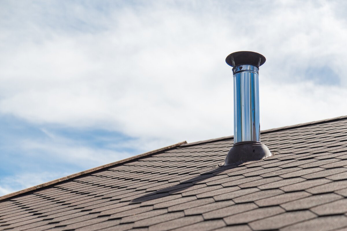 Chimney pipe from stainless steel on the roof of the house.