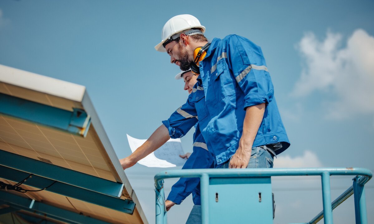 Solar engineers visually examine panel arrays on farm sites using blueprints and drawings to ensure that the alignment,…